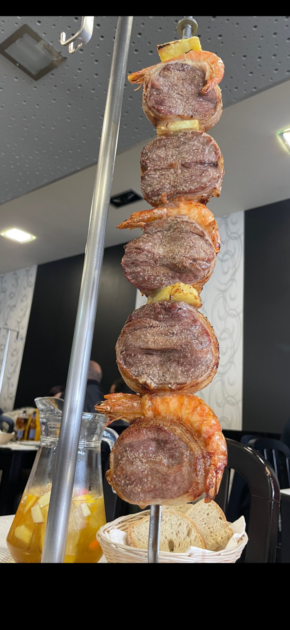 Espeto já grelhado no carvão, servido à mesa com sangria